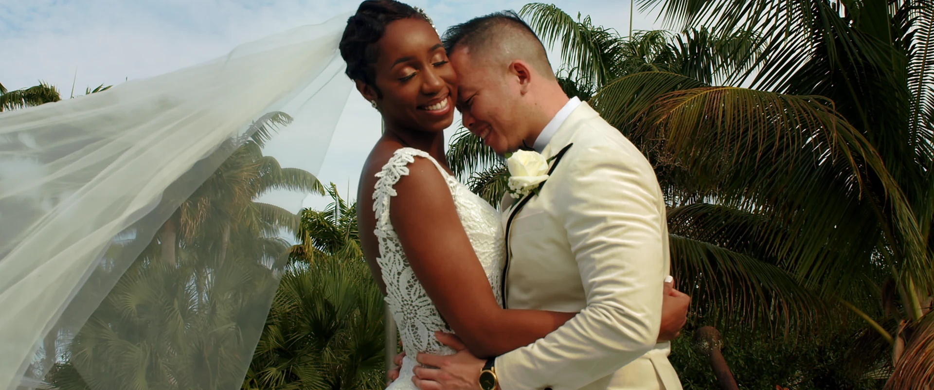 A quiet embrace between the newlyweds beneath a veil.