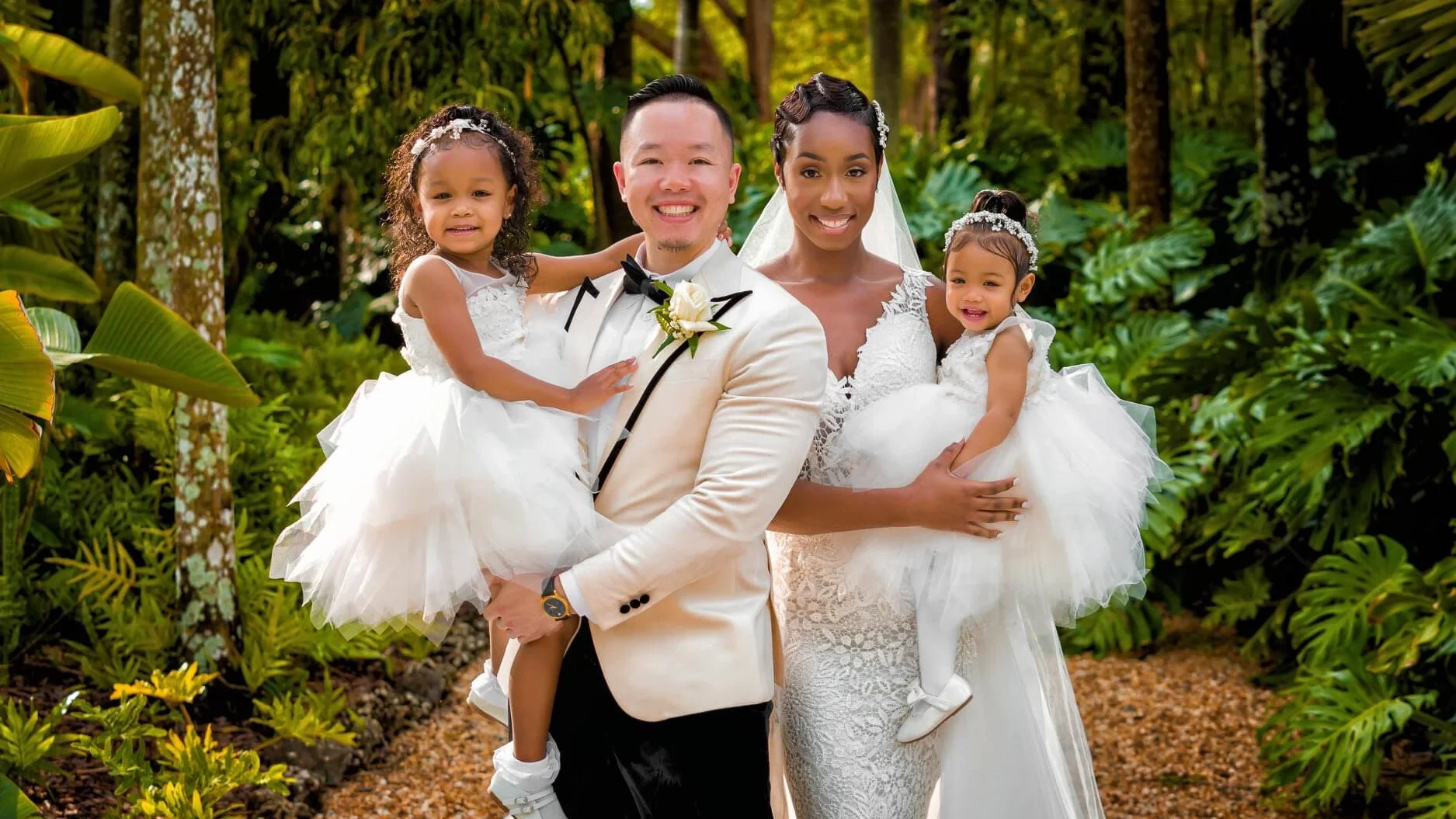 The Daos and their daughters standing together in a garden.